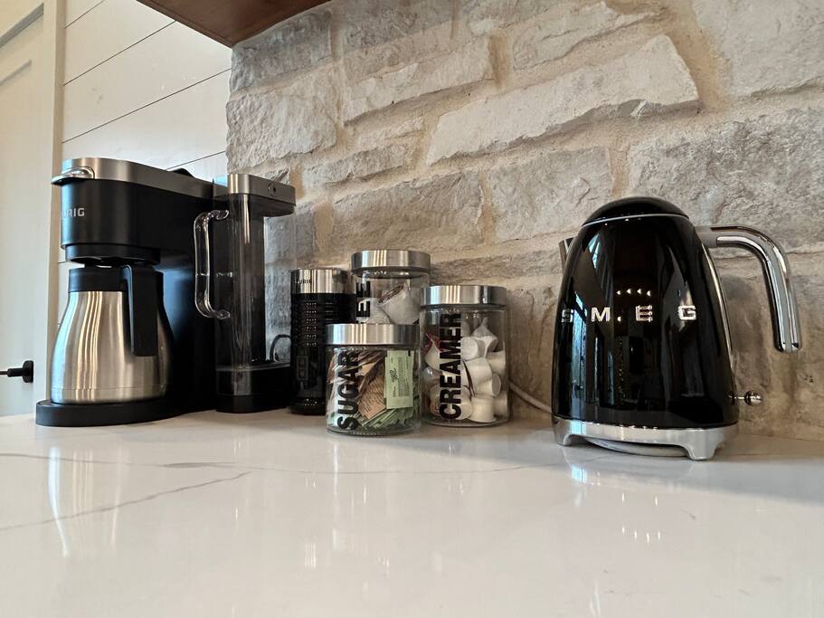 Stylish coffee and tea station with a modern kettle, coffee maker, and essentials.
