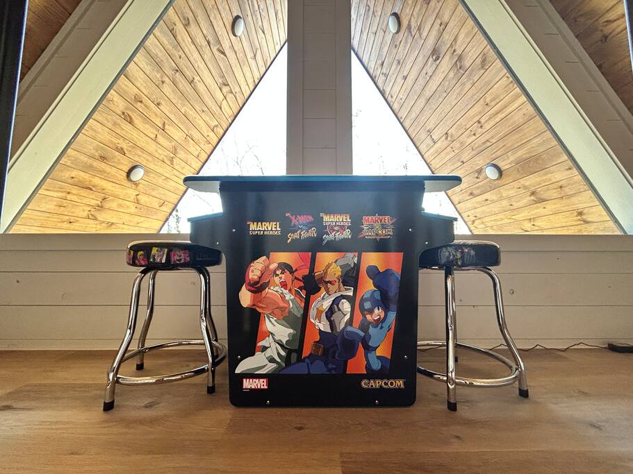 Retro arcade setup with Marvel vs Capcom games in a stylish attic.