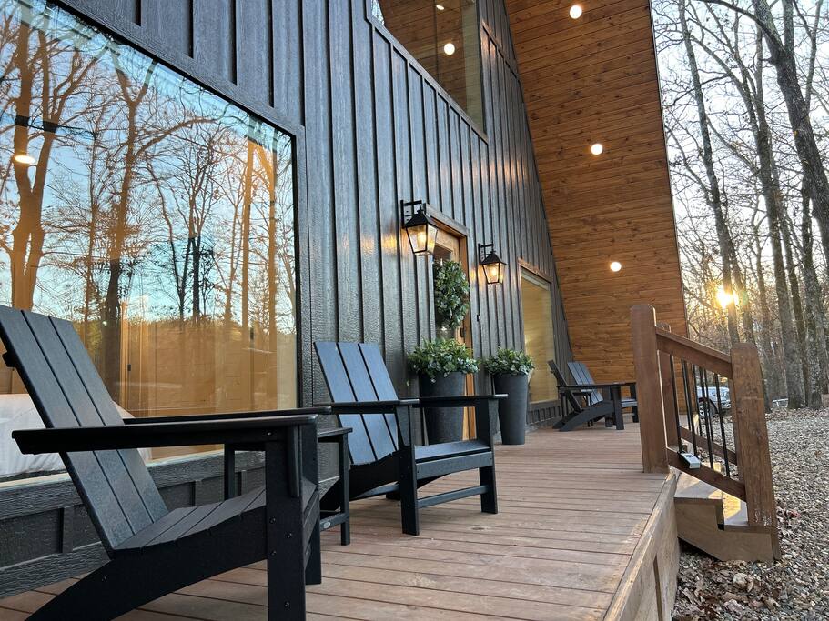 Modern cabin with cozy outdoor seating and scenic forest views.