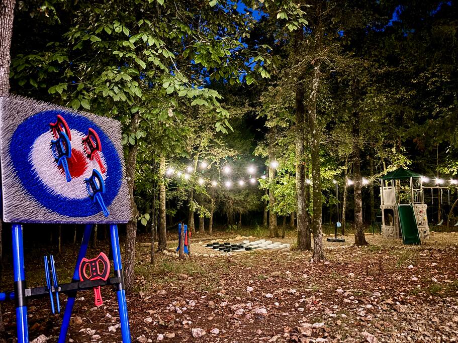 Warm cabin retreat with outdoor games and scenic forest views at dusk.
