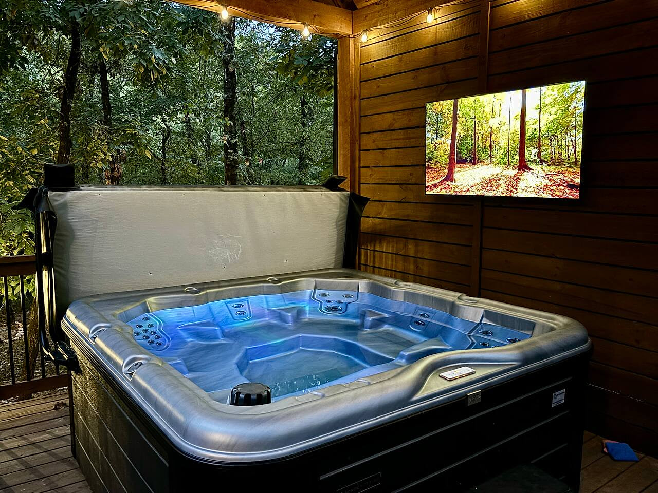 Relaxing hot tub with forest view and outdoor TV in Broken Bow, OK.