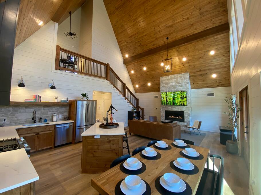 Rustic-modern cabin with cozy fireplace, vaulted ceilings, and elegant dining area.