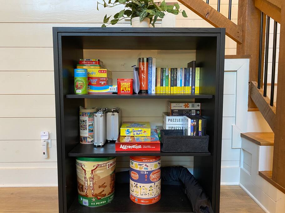 Cozy cabin bookshelf with games, puzzles, and books for family fun and relaxation.