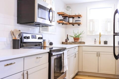 Quartz countertops, tile backsplash and locally sourced heart pine floating shelves.