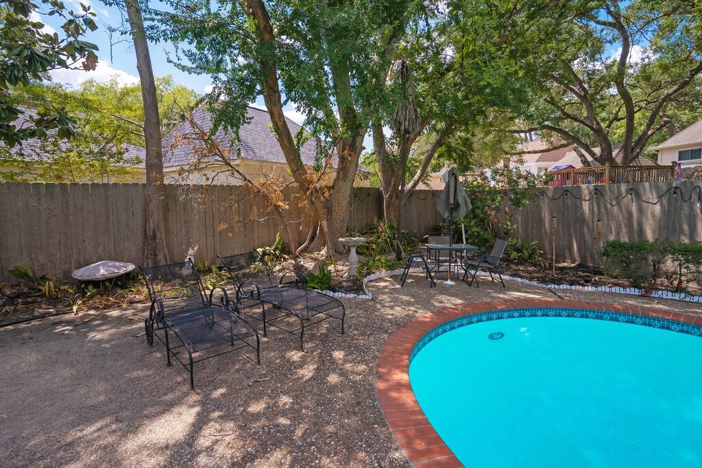 Deep end of pool (very deep... like 8-10 feet!), fire pit, wood, sunbathing chairs, and table with chairs. - Spacious & Quiet 4 bed/3.5 bath home in Katy - Katy