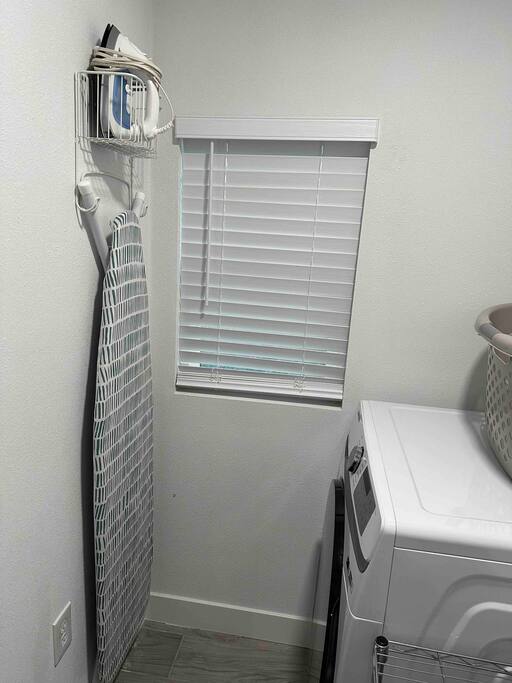 Laundry room with ironing board and iron.