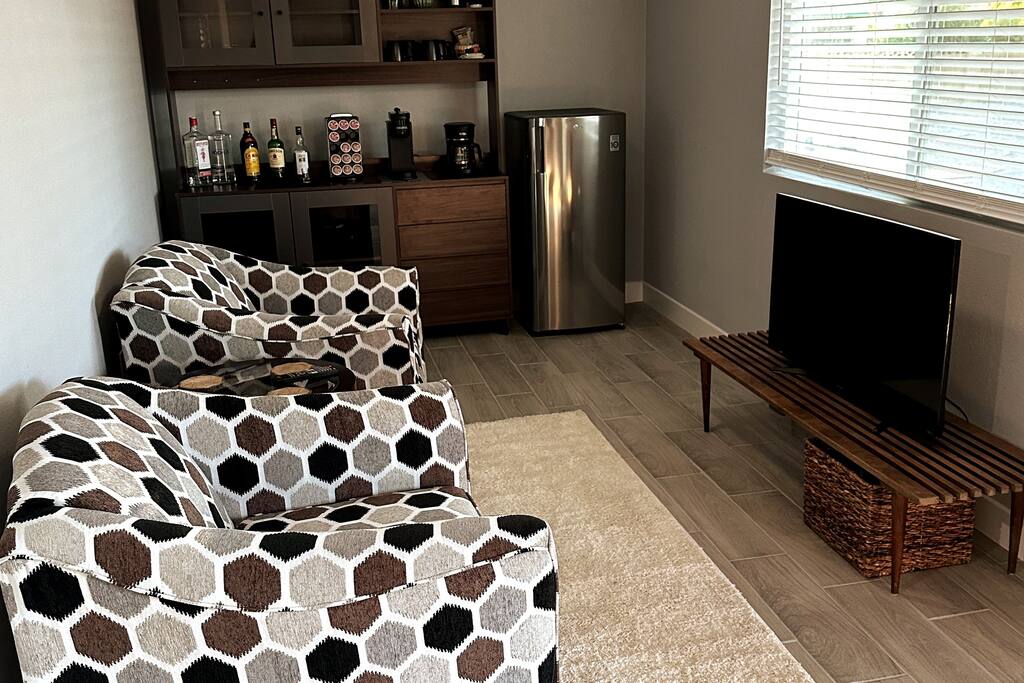 Seating area with mini-fridge and 42" Roku TV.  Bar/pantry wall unit with coffee station.  This room also has a ceiling fan. This tv has been moved into master bedroom.