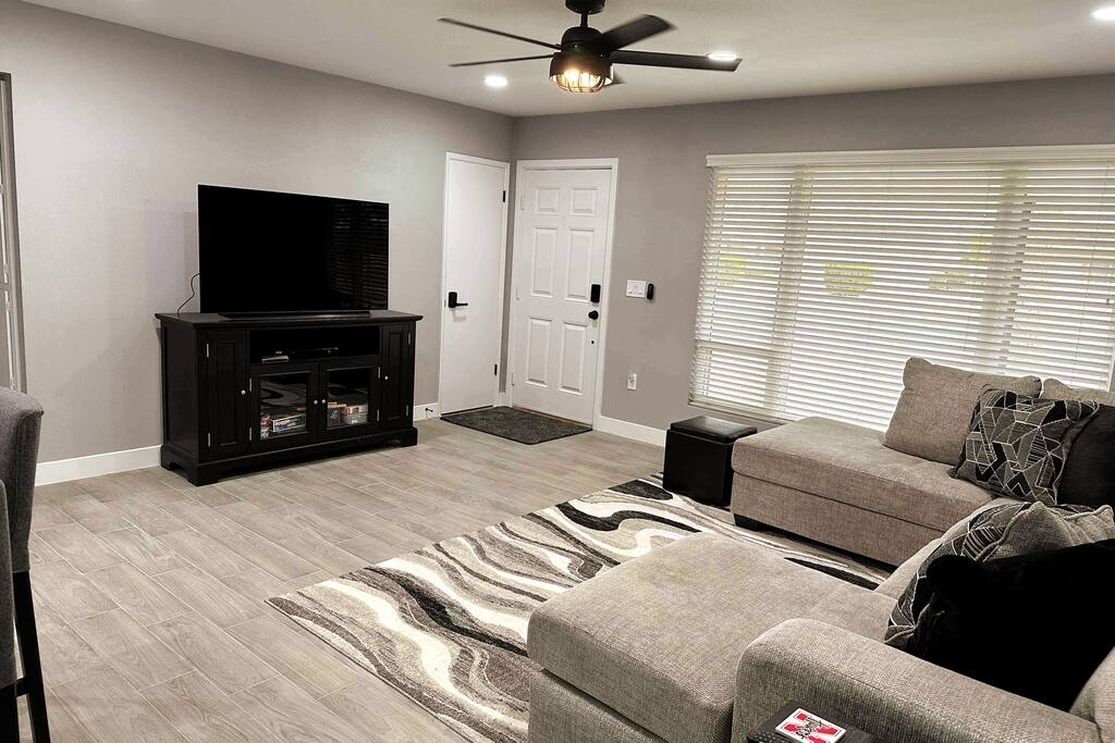 Looking from garage entrance. Brand new sectional in living room. Ceiling fan Smart TV