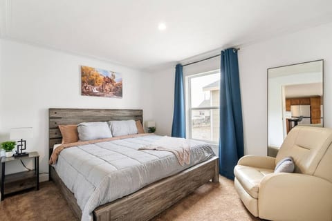 Second bedroom with a Helix Luxe king-size mattress, nightstands with adjustable lamps, blackout curtains, and full-length mirror..