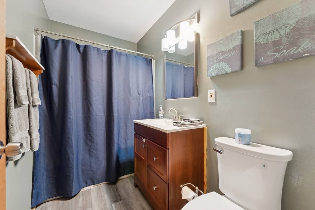 Cabin main level full bathroom with tub/shower, shampoo, conditioner, body wash, soap, hairdryer, towels, washcloths, and extra towels. Cabin main level full bathroom with tub/shower, shampoo, conditioner, body wash, soap, hairdryer, towels, washcloths, and extra towels. - Eagle Bluff Estate - Mauston