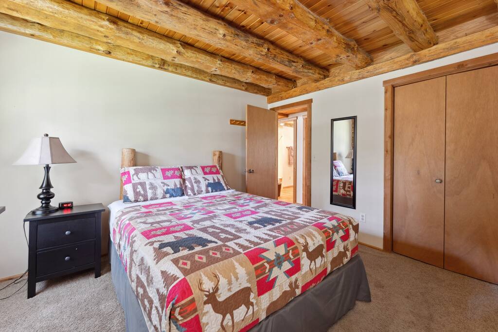 Main level lodge queen bedroom includes Roku TV, dresser, alarm clock with USB charger, portable fan, extra pillow and blankets, and closet with hangers. Main level lodge queen bedroom includes Roku TV, dresser, alarm clock with USB charger, portable fan, extra pillow and blankets, and closet with hangers. - Eagle Bluff Estate - Mauston