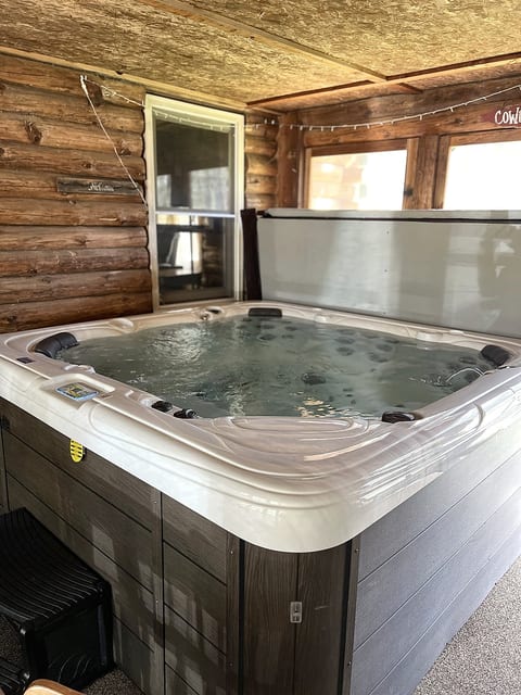Private indoor hot tub in a cozy rustic cabin-style sunroom