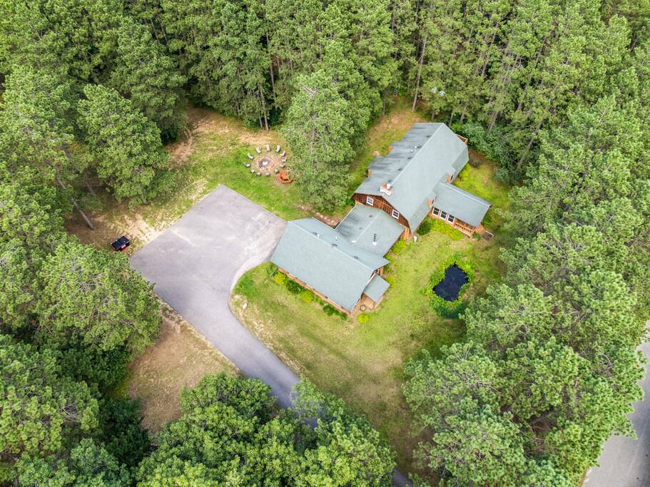 Drone photo with an amazing view of Eagle Bluff Estate featuring the large driveway for vehicles and adult toys, fire pit with a large seating area, and pond in the front. Drone photo with an amazing view of Eagle Bluff Estate featuring the large driveway for vehicles and adult toys, fire pit with a large seating area, and pond in the front. - Eagle Bluff Estate - Mauston