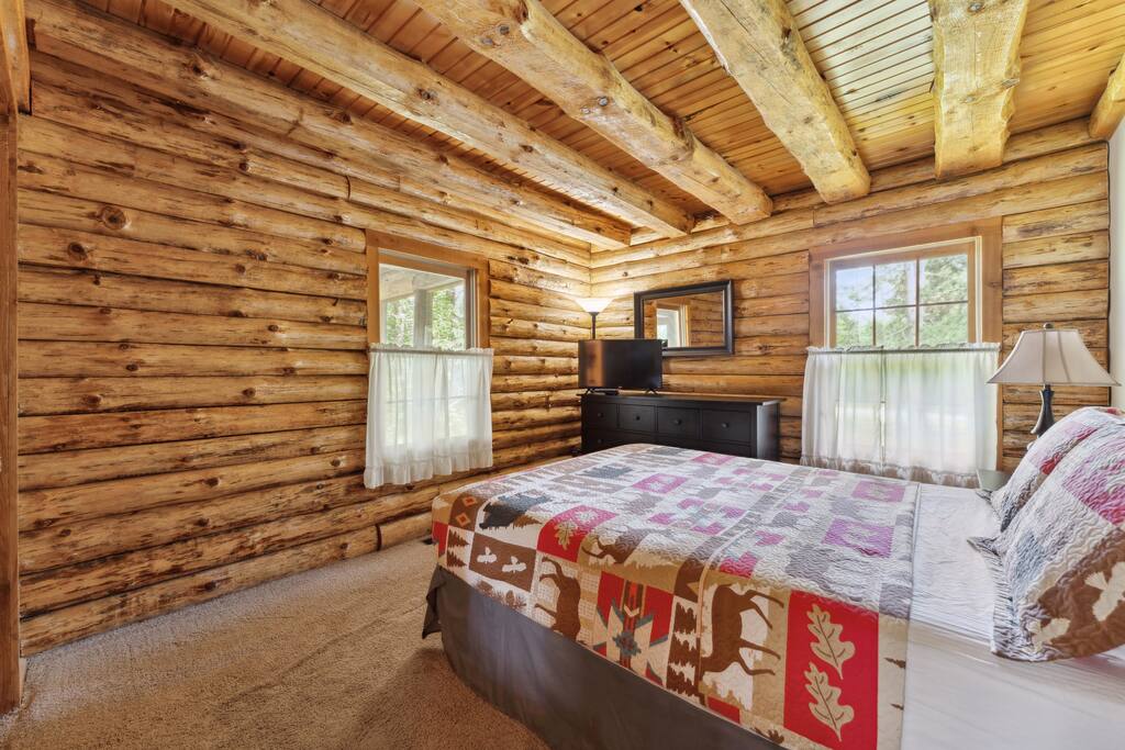 Main level lodge queen bedroom includes Roku TV, dresser, alarm clock with USB charger, portable fan, extra pillow and blankets, and closet with hangers. Main level lodge queen bedroom includes Roku TV, dresser, alarm clock with USB charger, portable fan, extra pillow and blankets, and closet with hangers. - Eagle Bluff Estate - Mauston