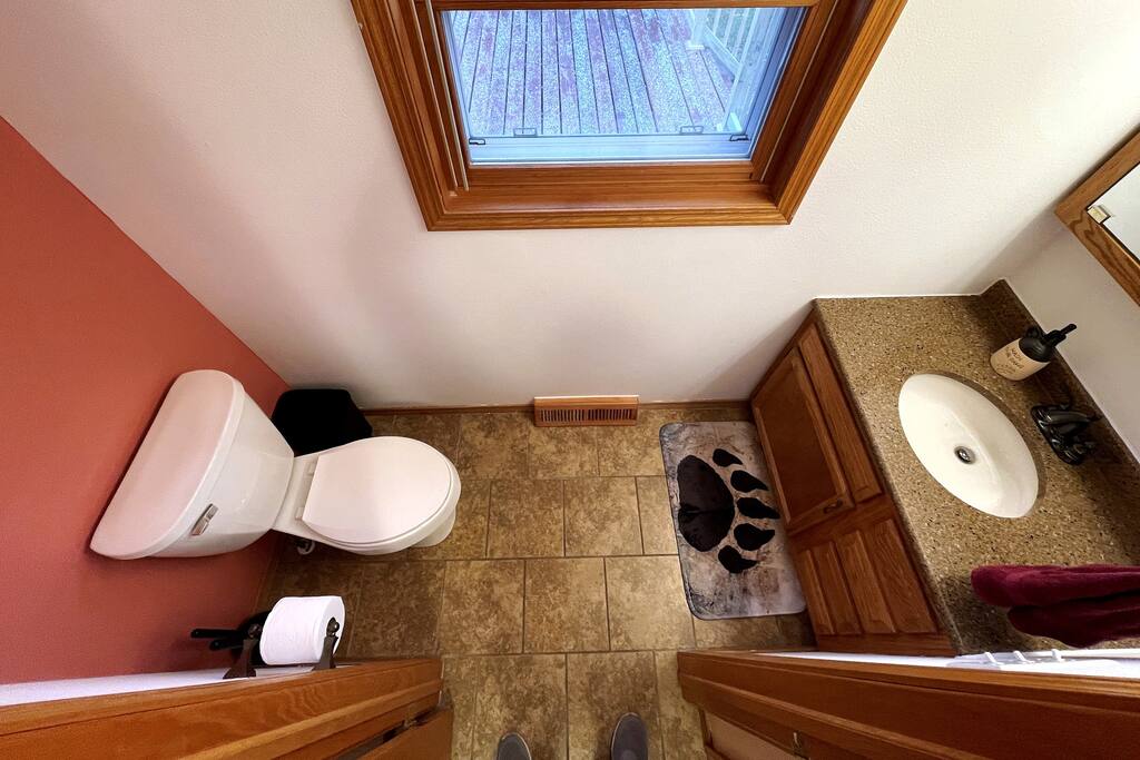 Main Level 1/2 Bath featuring toilet and sink. Main Level 1/2 Bath featuring toilet and sink. - Bear Cove Escape - Lyndon Station