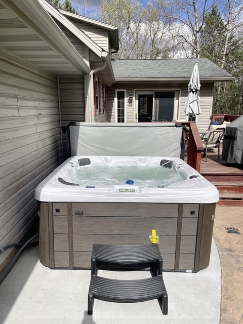 Private outdoor hot tub with deck seating and grill area