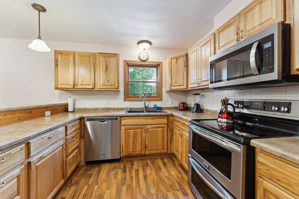 Kitchen featuring stove, microwave, fridge, dishwasher, pots & pans, Keurig, teapot and tea, dinnerware, small spice selection, and much more. Kitchen featuring stove, microwave, fridge, dishwasher, pots & pans, Keurig, teapot and tea, dinnerware, small spice selection, and much more. - Bear Cove Escape - Lyndon Station