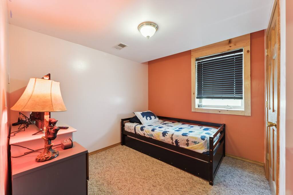 Basement bedroom with one trundle (two twin beds), dresser, Roku TV, USB charging ports, alarm clock, hangers, closet, and many games and toys. Basement bedroom with one trundle (two twin beds), dresser, Roku TV, USB charging ports, alarm clock, hangers, closet, and many games and toys. - Bear Cove Escape - Lyndon Station
