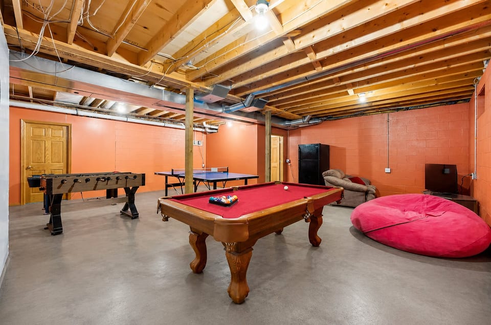 Spacious game room with pool, foosball, ping pong, and lounge seating