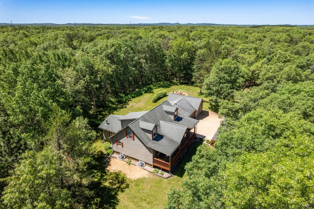 Exterior of the home from drone view. This home features 6 acres including trails, firepit, gas and charcoal grills, porch, and deck. Exterior of the home from drone view. This home features 6 acres including trails, firepit, gas and charcoal grills, porch, and deck. - Bear Cove Escape - Lyndon Station