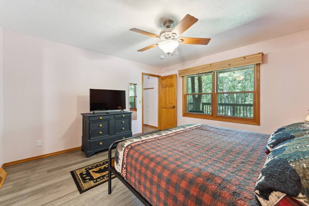 Master Suite Main Level Bedroom with a king bed, Roku TV, USB charging ports on lights, dresser, closet with hangers, master bathroom connected to the bedroom with tub/shower, hairdryer, and iron/ironing board. Master Suite Main Level Bedroom with a king bed, Roku TV, USB charging ports on lights, dresser, closet with hangers, master bathroom connected to the bedroom with tub/shower, hairdryer, and iron/ironing board. - Bear Cove Escape - Lyndon Station