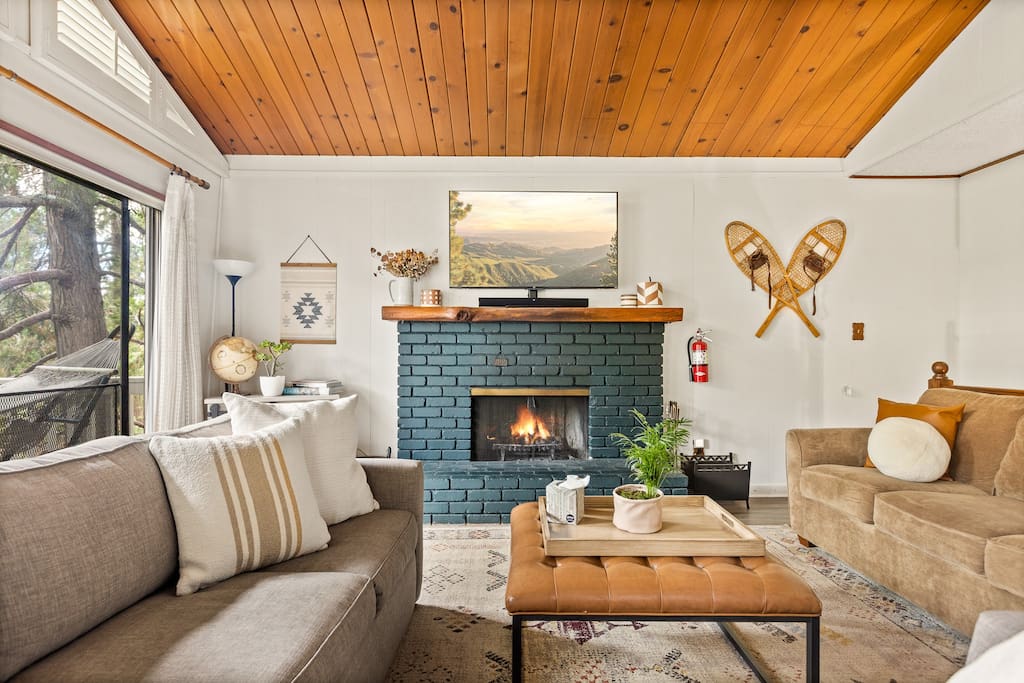 Living room with plenty of seating, rustic cabin decor and treetop + mountain views - SugarPine Chalet close to lake, pet/child friendly - Crestline