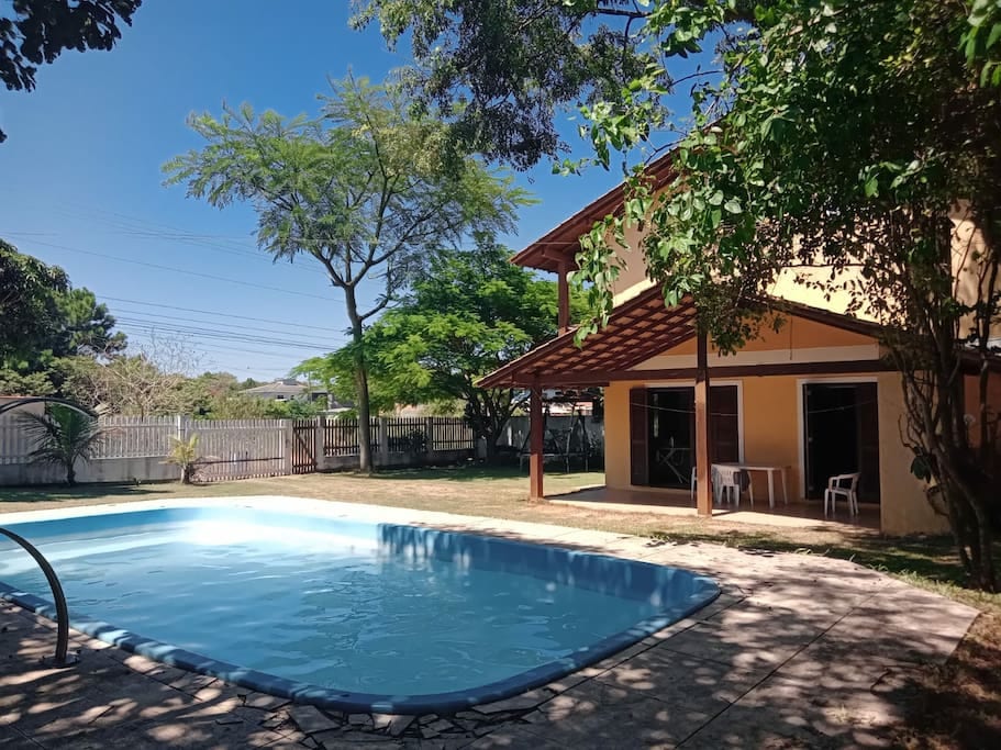 Piscina no jardim, com profundidade de 1,5 m e lugar para sentar.
