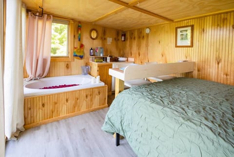 As you walk in the front door.  Queen bed to the right, wall of windows to the left.  Back of the house find bath tub, eating nook area, counter top with sink.  All while inhaling the sweet smell of cedar wood walls.

Bath tub closes Sept 18.