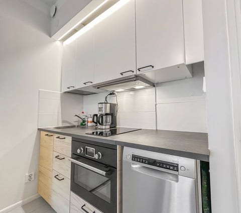 There's a newly built, full kitchen! The kitchen has an oven, dishwasher, integrated stove, coffee machine, electronic kettle, a range hood, and some other basic kitchen appliances such as silverware, pots and pans.
