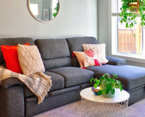 Plump couch, throw blankets and pillows make the space warm and inviting. Perfect for wintery West Coast nights or warm summer days.