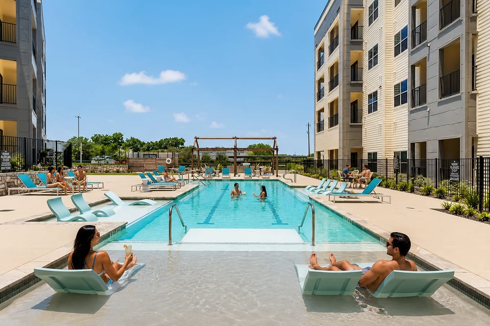 Resort-style pool with in-water loungers and sunny courtyard seating