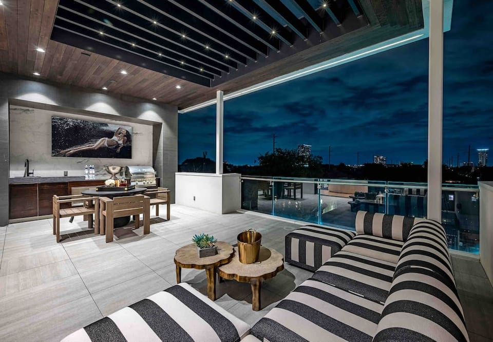Rooftop Terrace: lounge area, dining table, and 82” outdoor tv