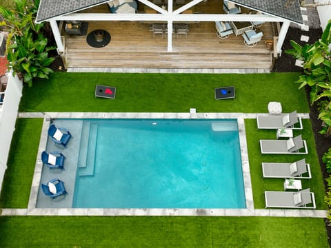 Resort-style relaxation, completely private.
A sparkling pool with sun shelf loungers, turf for yard games, and shaded outdoor living just steps away — thoughtfully designed for effortless vacation days.