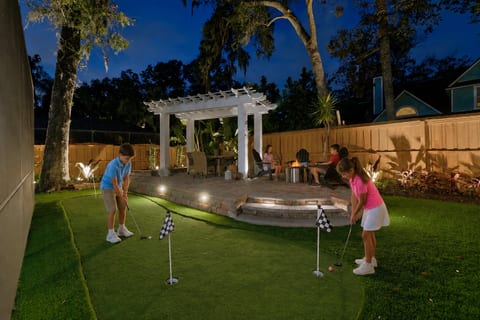 Putting green with pergola and seating area around the fire pit