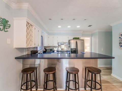 Kitchen has bar seating, new appliances and corian countertops.