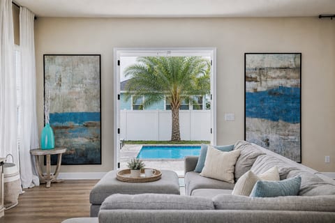 Bright, comfortable living room overlooking the private pool—perfect for morning coffee or relaxing after a day at the beach.