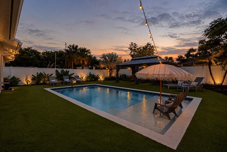 Backyard lit up at night for a true resort-style experience — perfect for evening swims and relaxing under the lights.