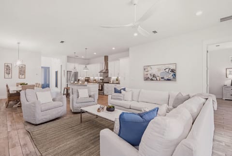 Spacious, light-filled living room with oversized seating and open flow into the kitchen and dining areas.