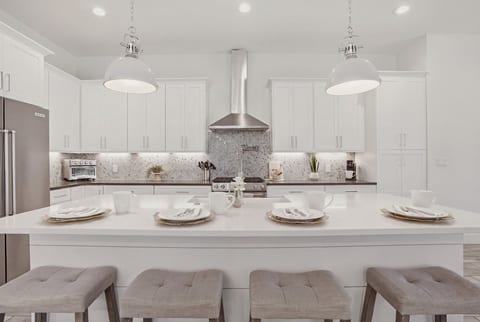 Bright chef’s kitchen with oversized island, modern finishes, and plenty of space for cooking and gathering.