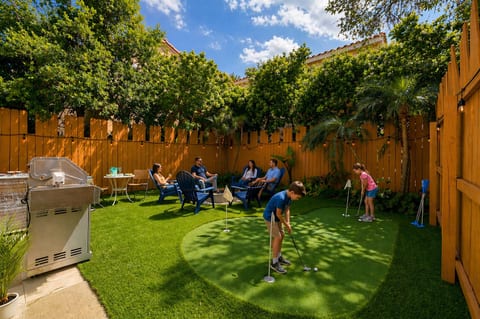 Kids on the putting green, adults relaxing nearby—this backyard is your own private retreat for sunshine, laughter, and a little friendly competition.