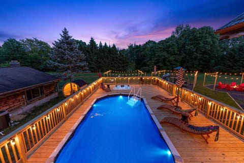 Marvel at the breathtaking dusk views from our spacious deck, overlooking the serene pool and expansive yard framed by beautiful trees. Perfect for relaxation and creating unforgettable memories.