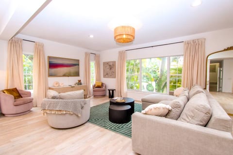 The living area with seating for eight, has views of the private garden set amongst oak trees, palm trees, birds of paradise making it the perfect place to relax and unwind or connect with friends and family. The sofa features a pull out queen bed. 