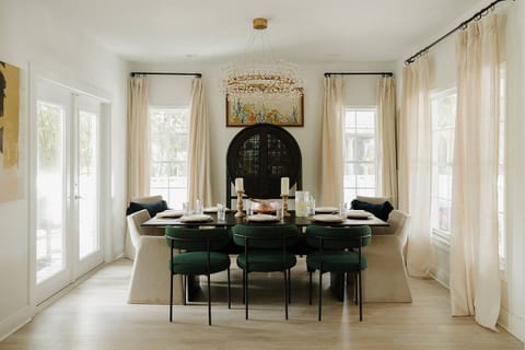 Bright dining area with seating for 8, surrounded by large windows and French doors overlooking the property’s tropical greenery. Perfect for family dinners, morning coffee, or gathering after a day in Tampa Bay.