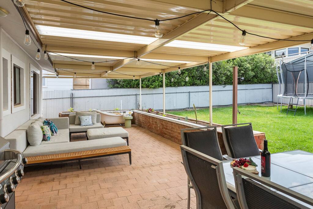 This backyard features an undercover area, perfect for outdoor dining or relaxing on the couches, plus has a luxurious bath. 

The large grass area includes a trampoline and basketball ring. The shed  - Family friendly - Outdoor bath/trampoline &more - Carrickalinga