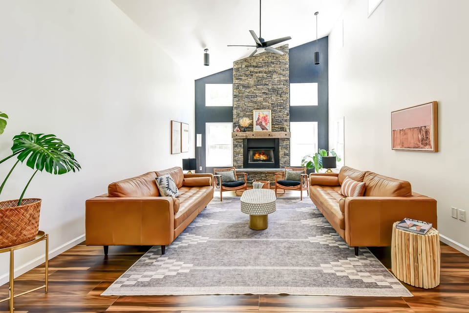 Bright vaulted living room with stone fireplace and stylish leather seating