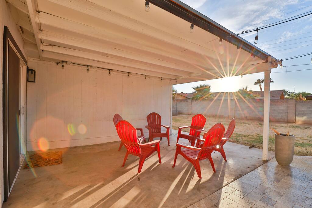 Backyard covered patio with 6 Adirondack chairs