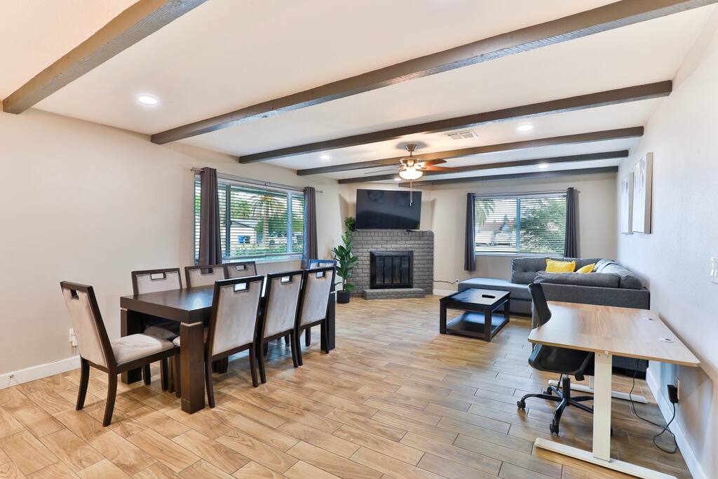 Open concept living room. Dining table with 8 chairs. Extendable computer desk with chair for working.