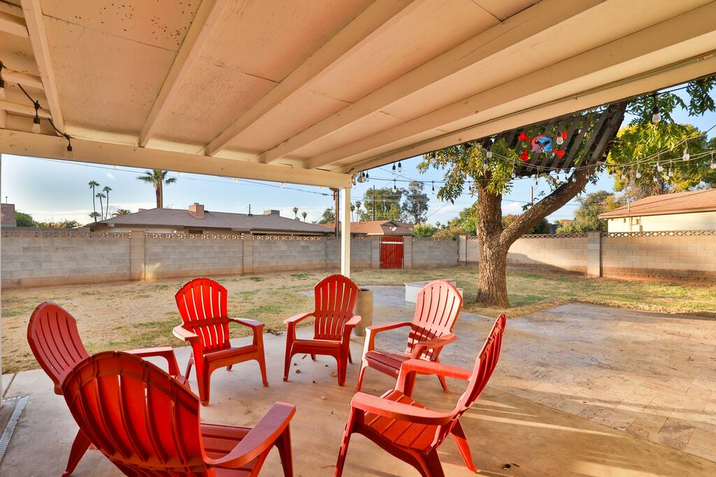 Covered backyard patio with 6 adirondack chairs