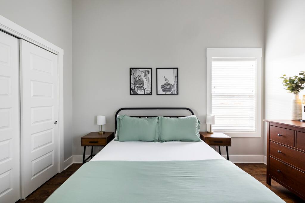 Bedroom | Queen Bed | Clean & Cozy
Simple and stylish bedroom with a queen bed, green bedding, music-themed wall art, double closet, and natural light—perfect for a restful night’s sleep.