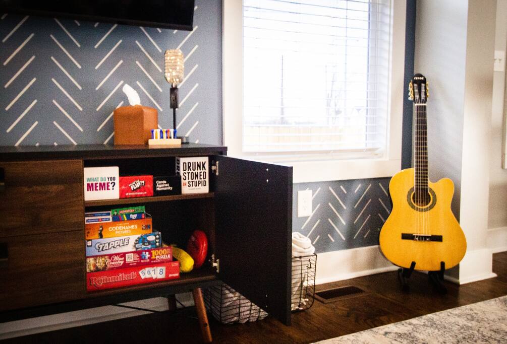 Assortment of board and card games and an acoustic guitar. - Underwood Manor - Nashville